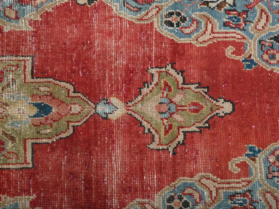 a close up of a red rug with blue and green designs