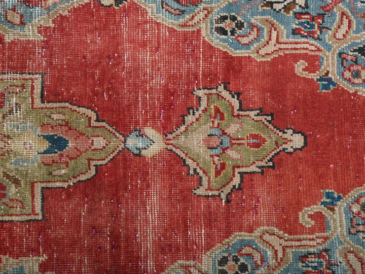 a close up of a red rug with blue and green designs