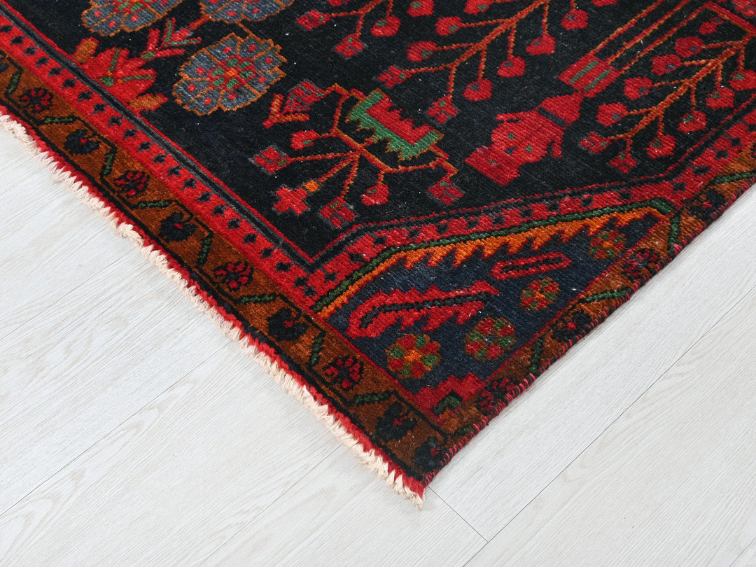 a red and black oriental rug on a white floor