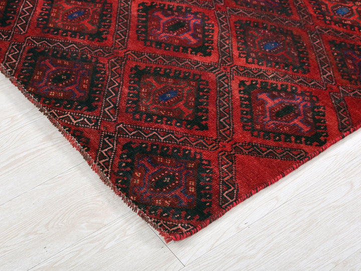 a red and black rug on a white floor