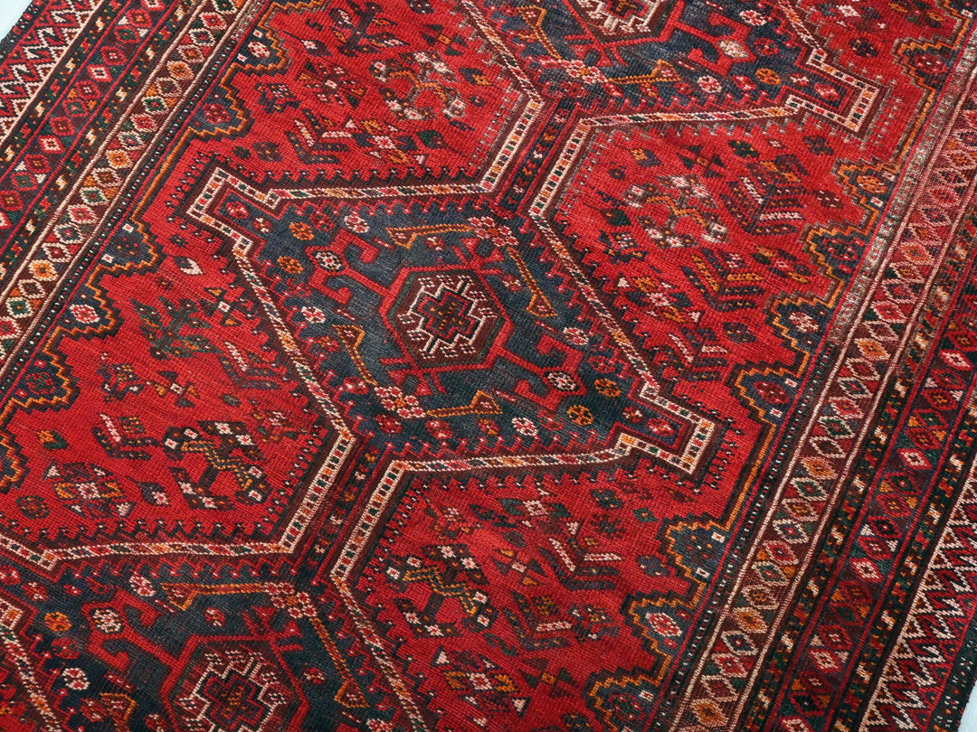 a red oriental rug with a black border