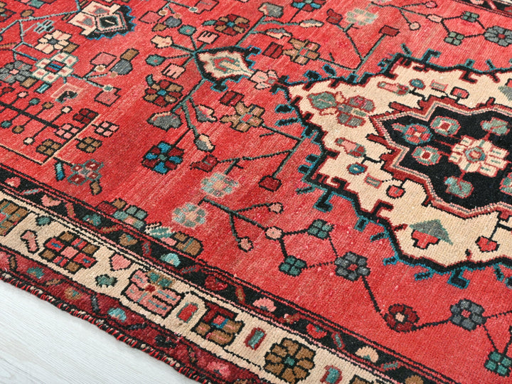 a red oriental rug with a black and blue design