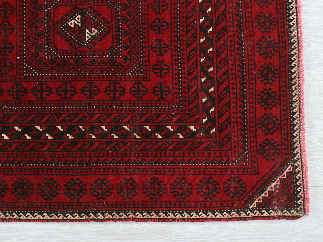 a red rug with black and white designs on it