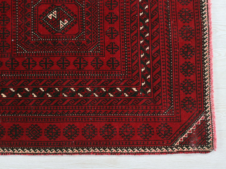 a red rug with black and white designs on it