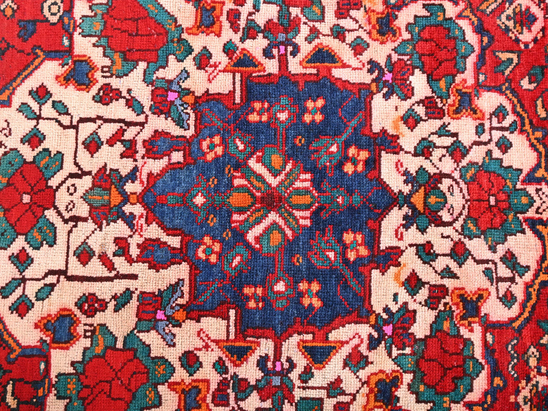 a red and blue rug with a floral design