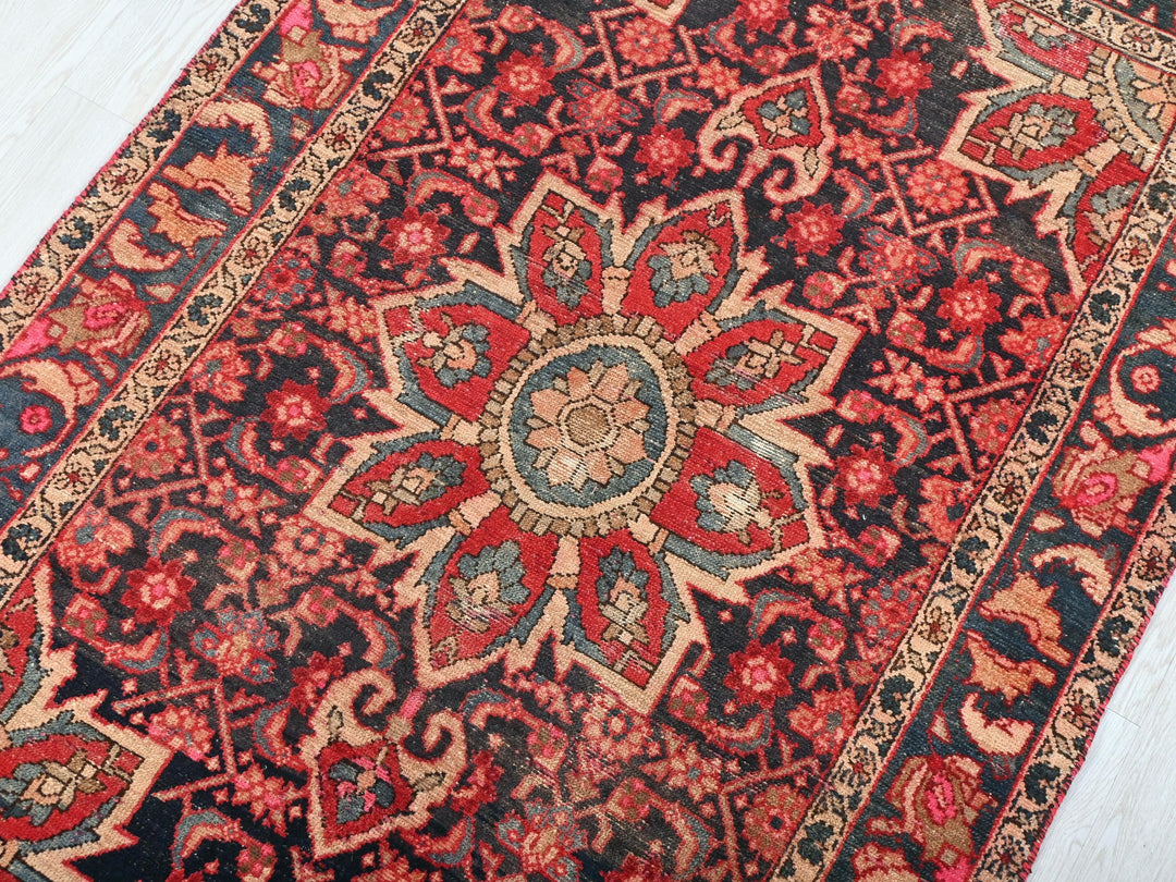a red and black oriental rug on a white floor