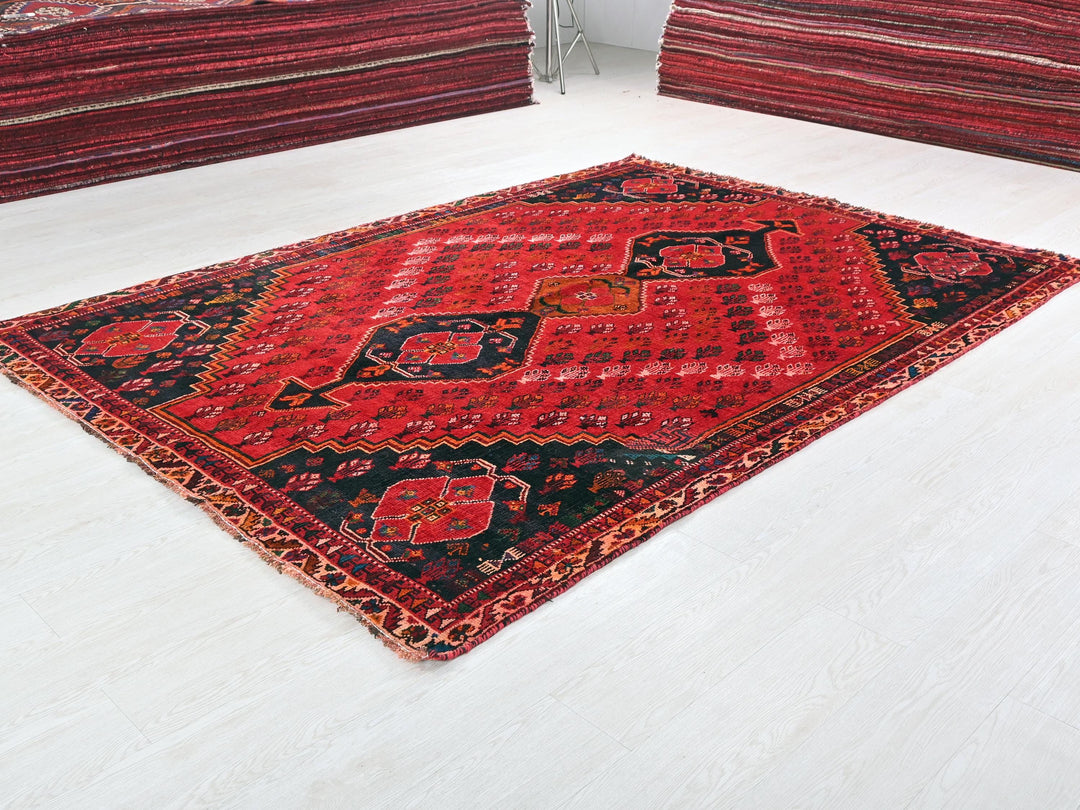 a red and black rug sitting on top of a white floor