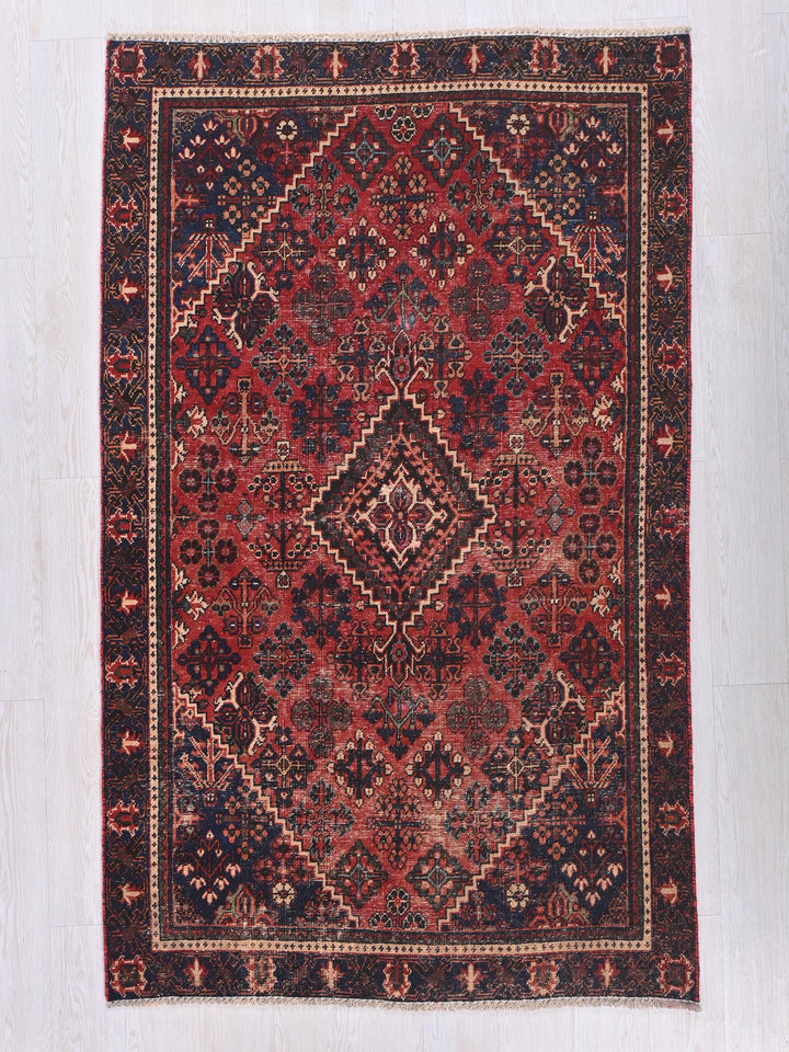 a red and blue rug with a diamond pattern