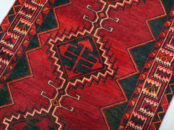 a close up of a red rug on a white floor