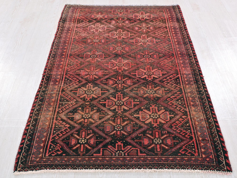 a red and black rug on a white floor