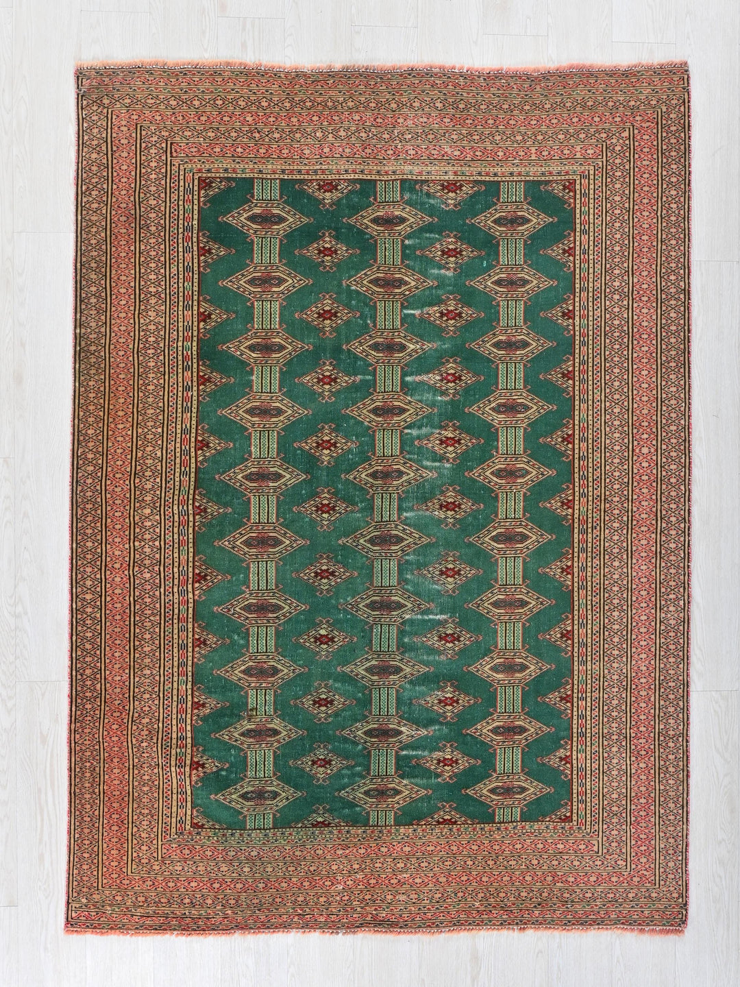 a green and red rug on a white floor