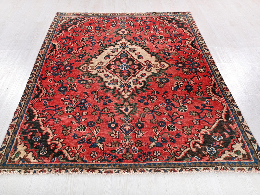 a red oriental rug on a white floor