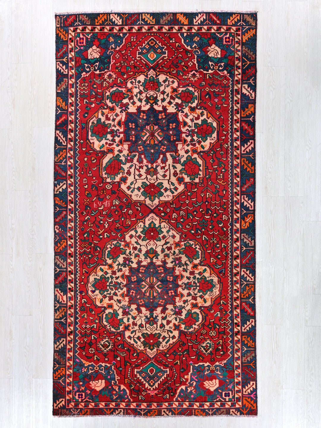 a red and blue rug with an intricate design