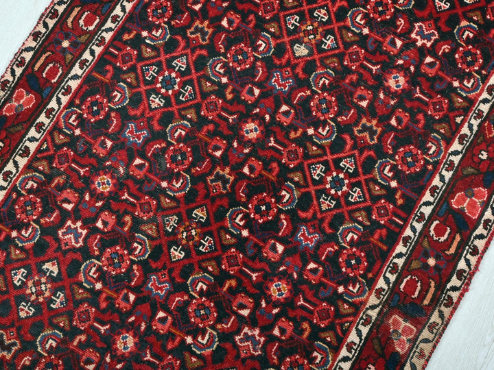 a red and black oriental rug on a white floor