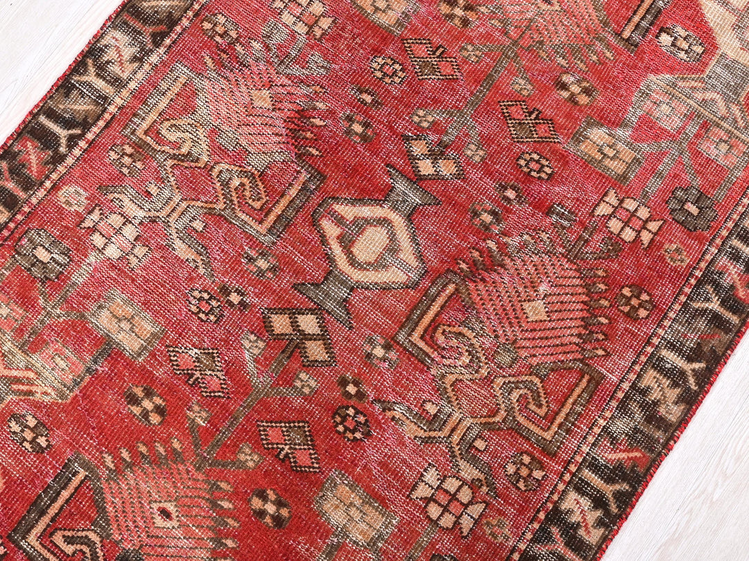 a red oriental rug on a white wooden floor