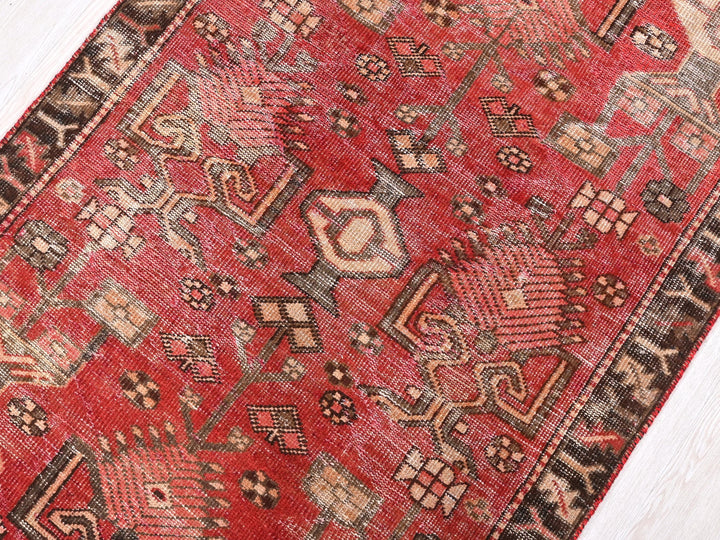 a red oriental rug on a white wooden floor