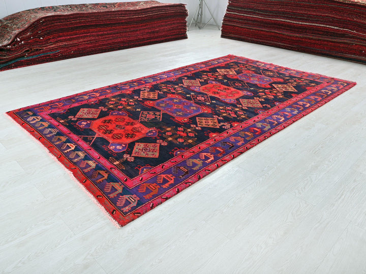 a pile of red rugs sitting on top of a white floor