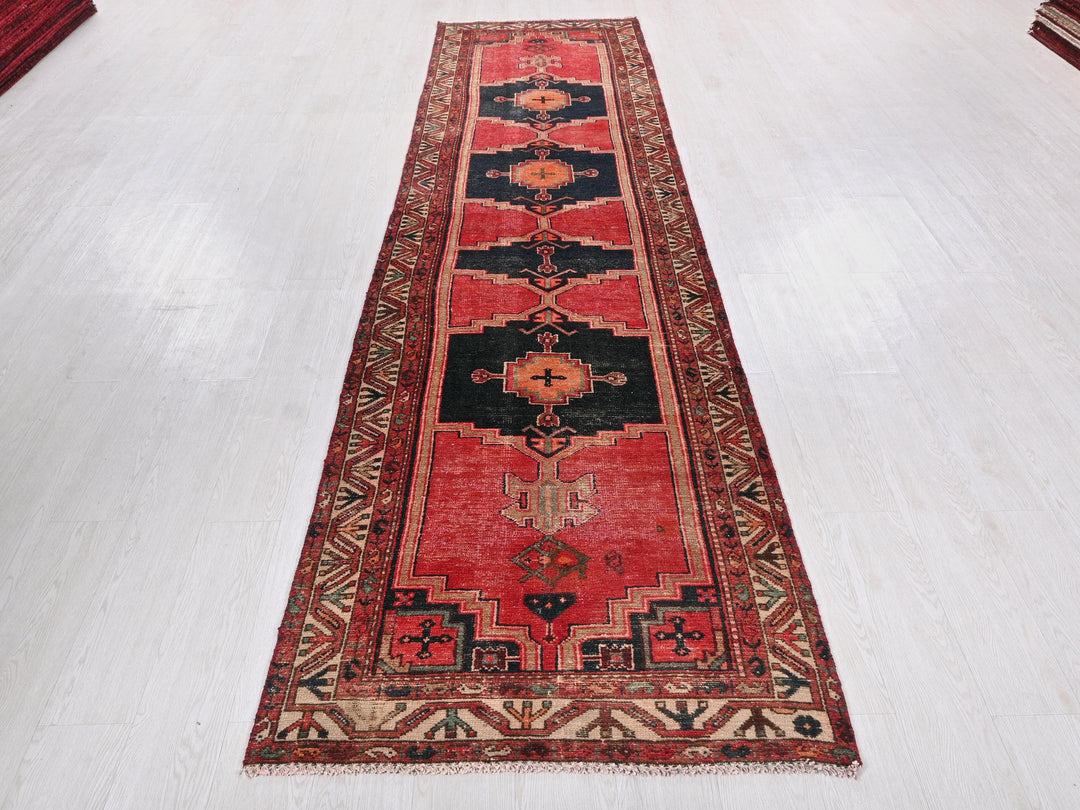 a red and black rug on a white floor