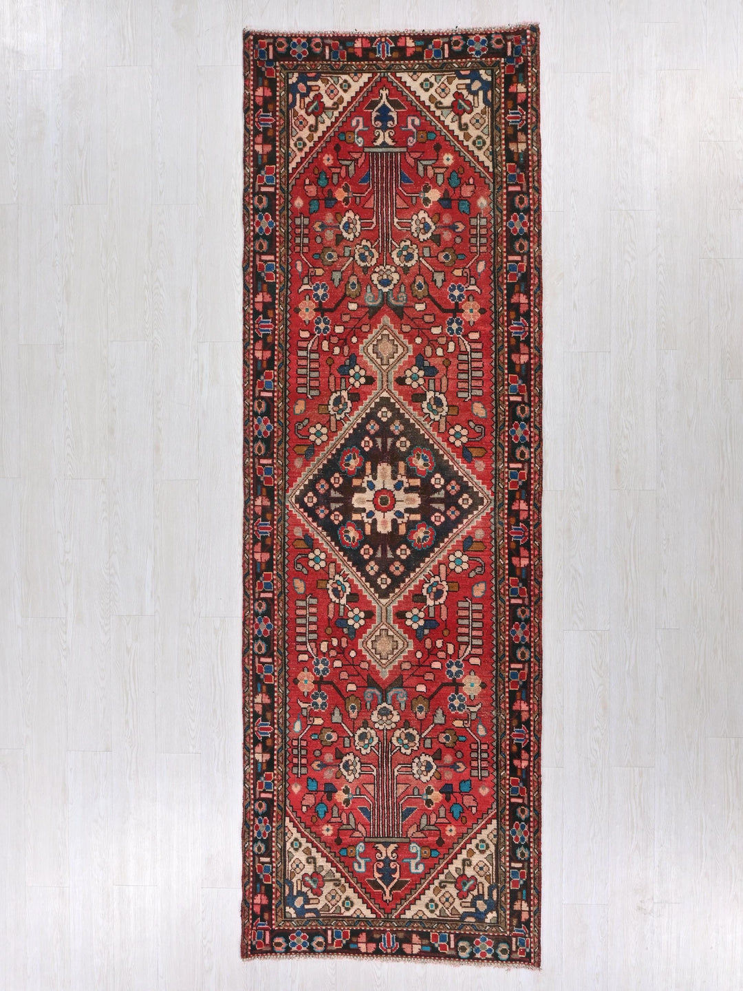 a red oriental rug hanging on a wall