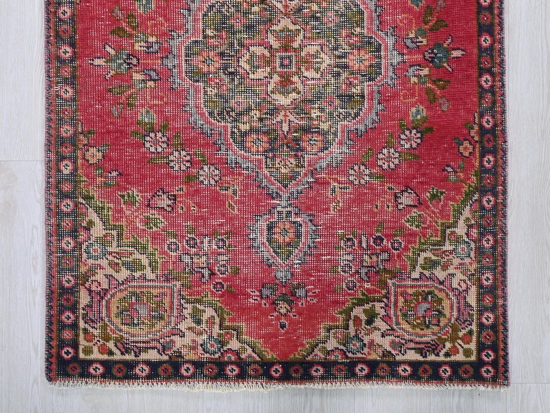 a red rug with a floral design on it