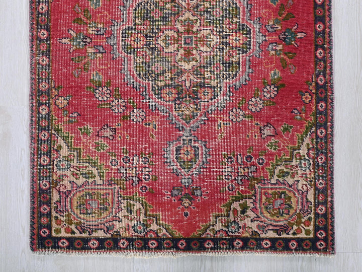 a red rug with a floral design on it