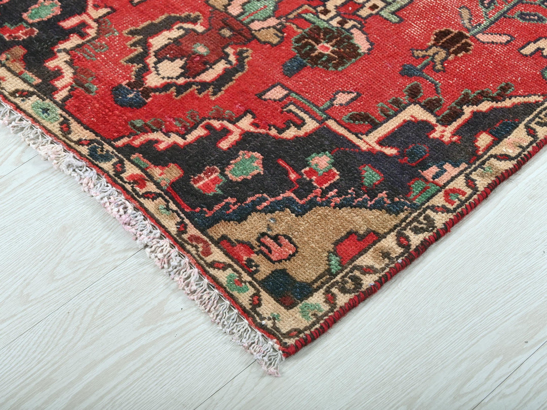 a red rug on a white wooden floor