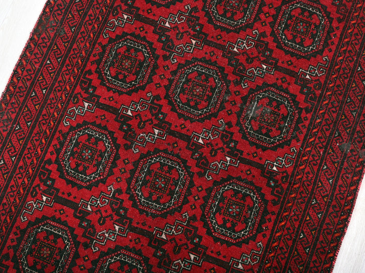 a red and black oriental rug on a white floor