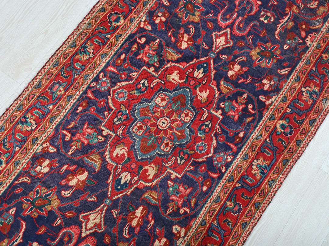 a red and blue rug on a wooden floor
