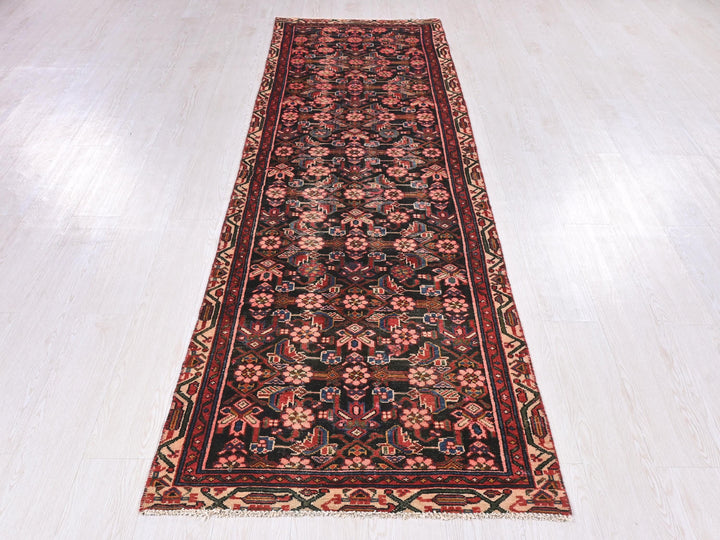 a red and black rug on a white floor