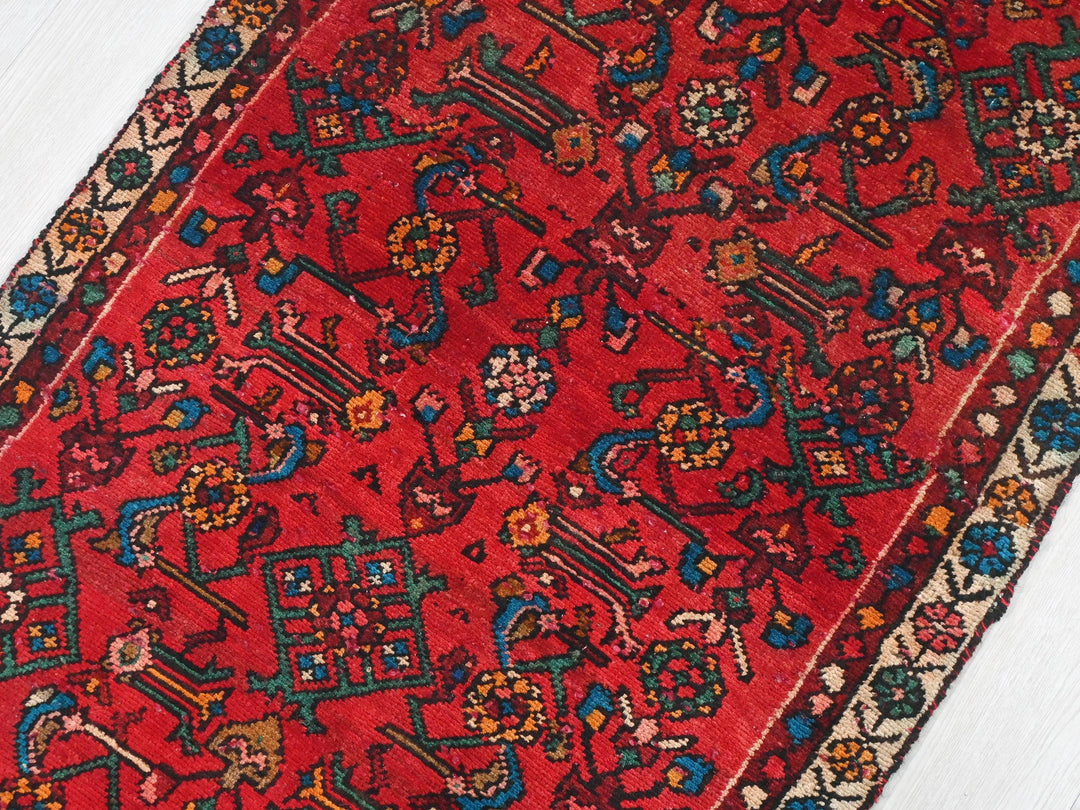 a red oriental rug on a white wooden floor
