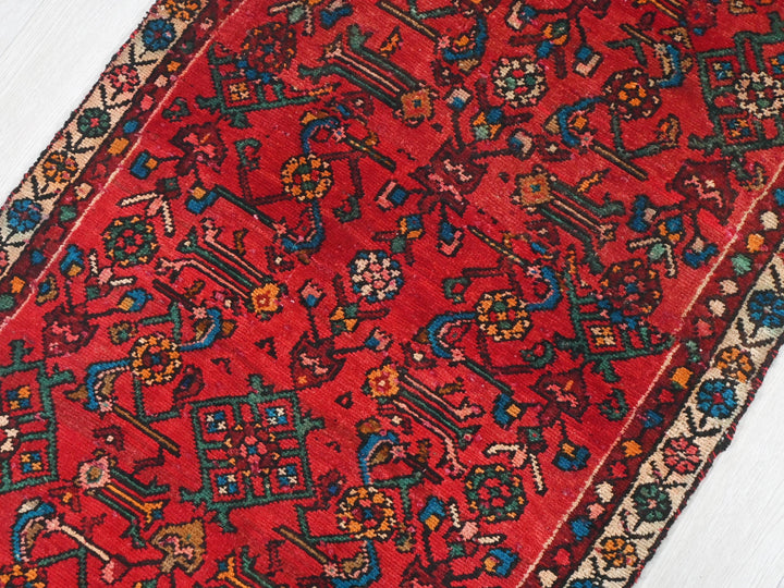 a red oriental rug on a white wooden floor