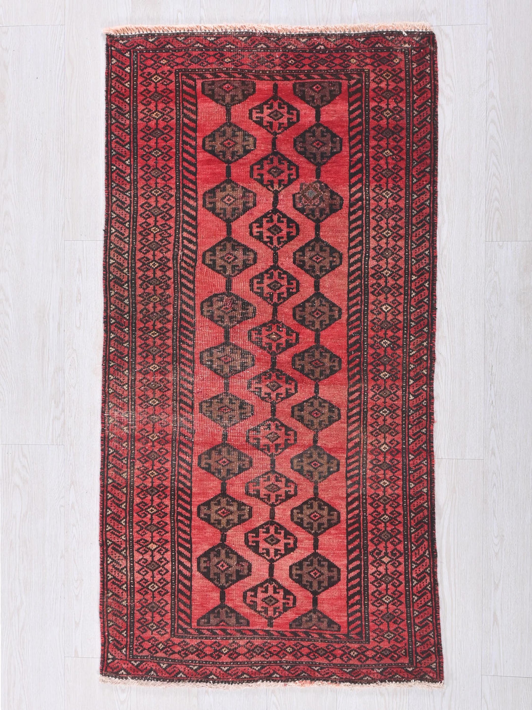 a red and black rug on a white floor