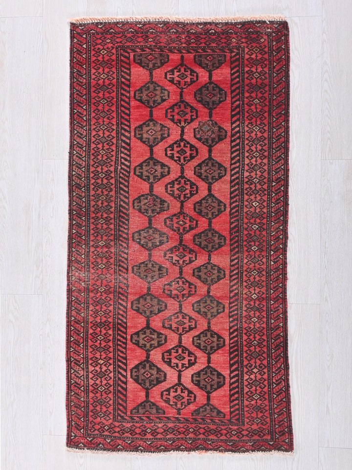 a red and black rug on a white floor