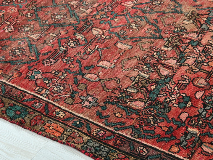 a red oriental rug on a white wooden floor