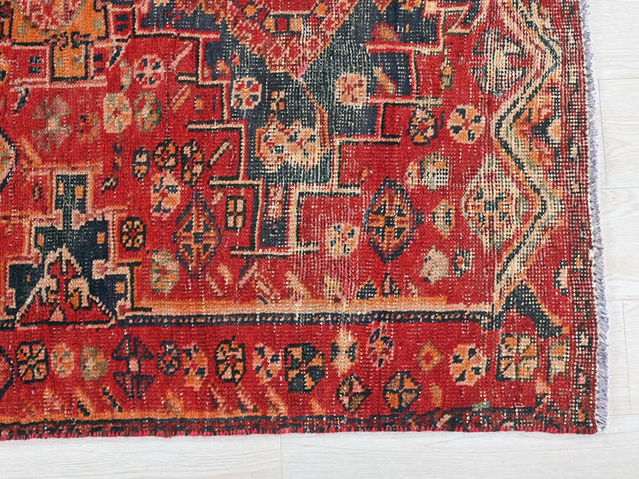 a red rug with a pattern on the middle of it