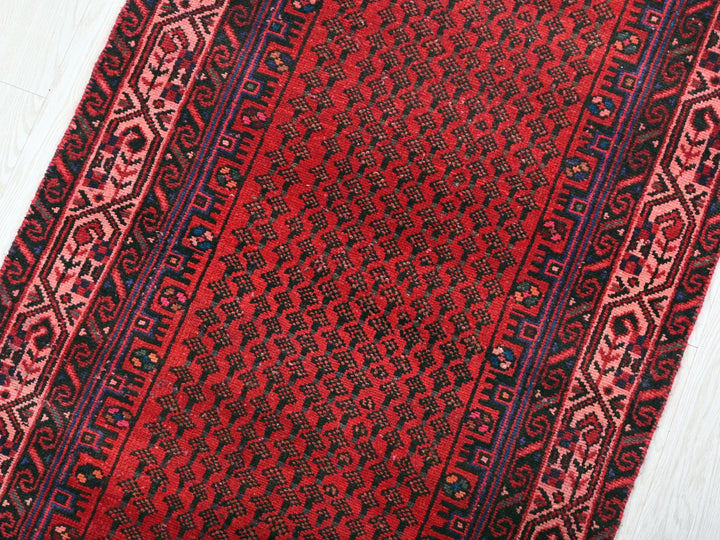 a close up of a red rug on a wooden floor
