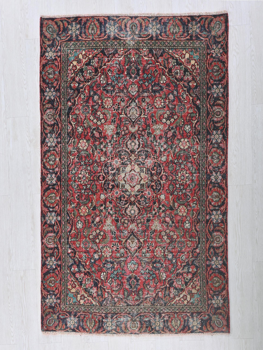 a red and blue rug on a white floor