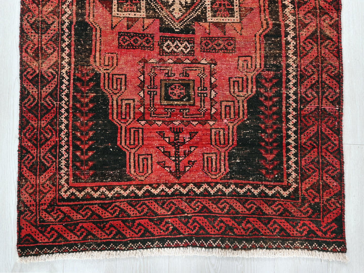 a red and black rug with a design on it