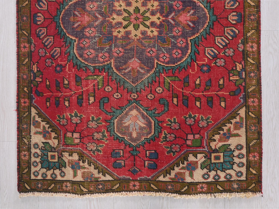 a red rug with a floral design on it