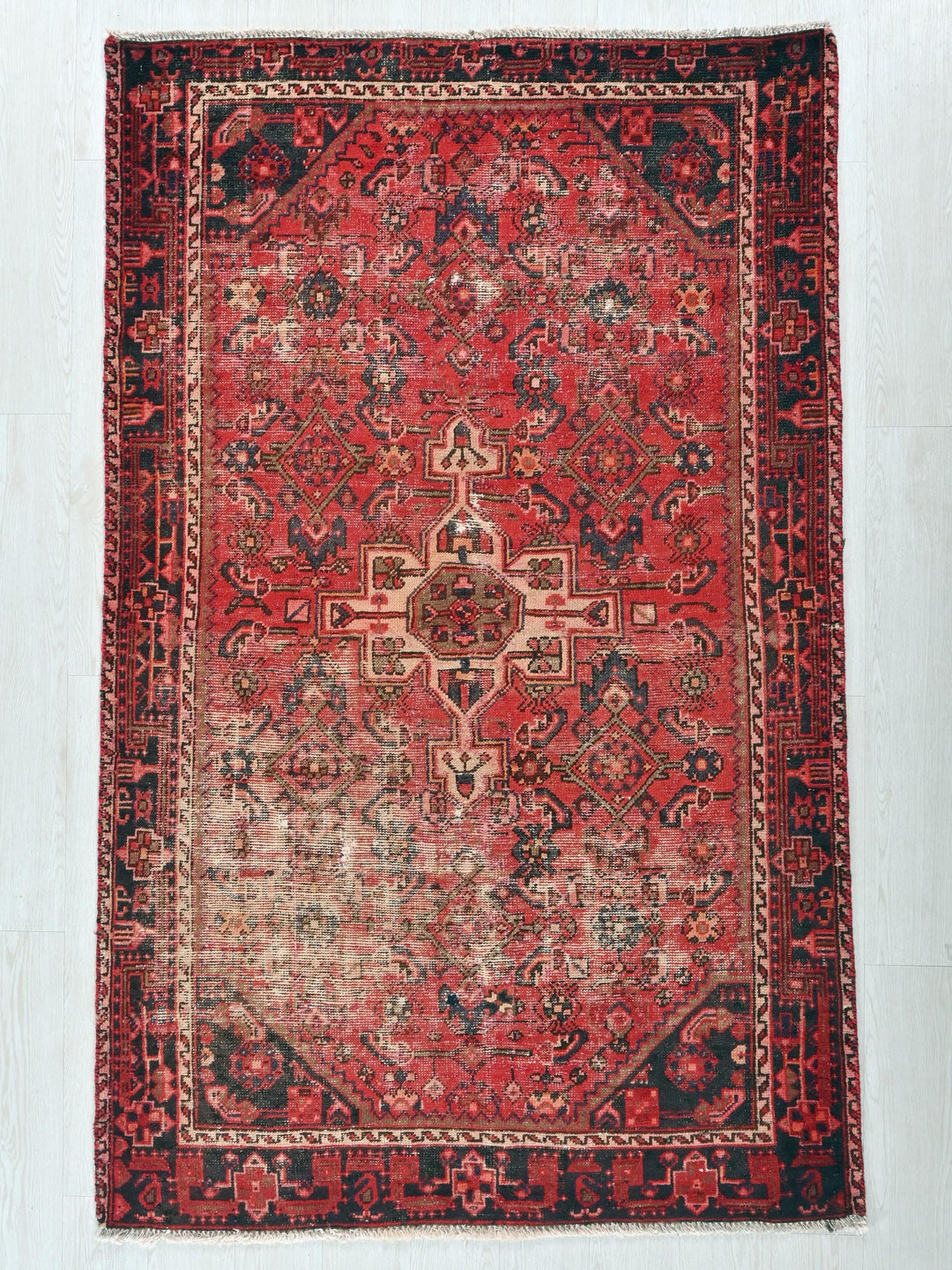 a red and black rug on a white floor