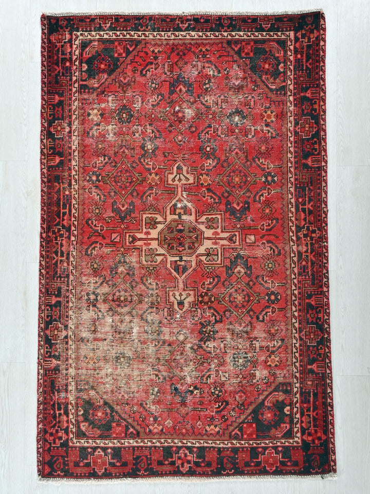 a red and black rug on a white floor