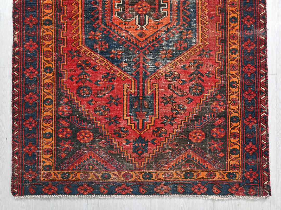 a red, blue, and orange rug with a design on it