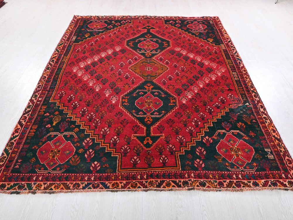 a red and black oriental rug on a white floor