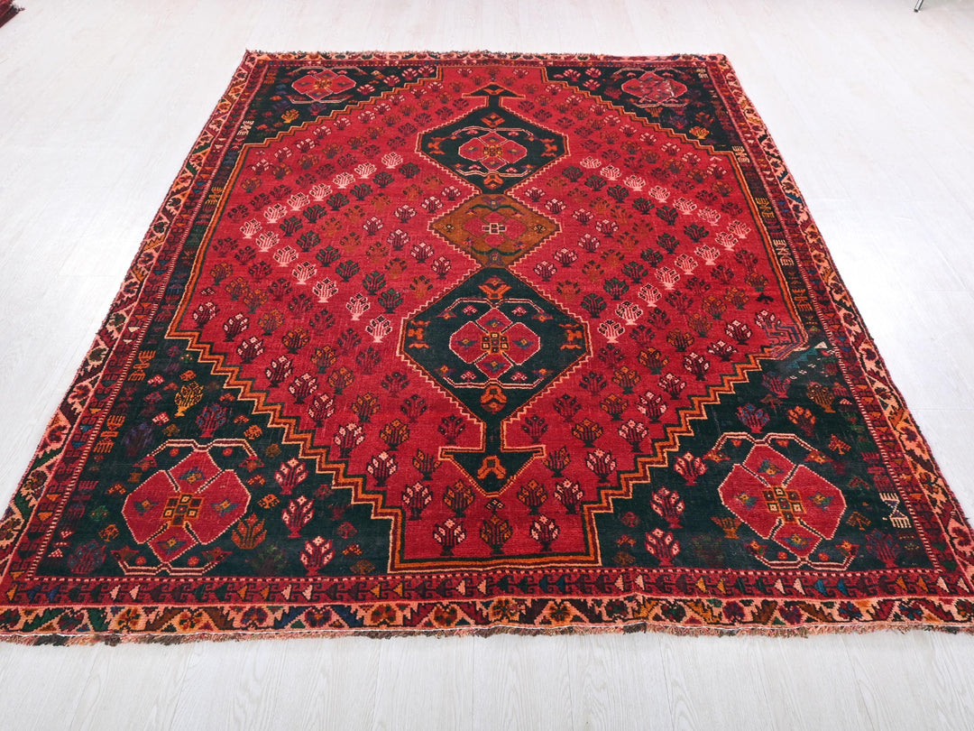 a red and black oriental rug on a white floor