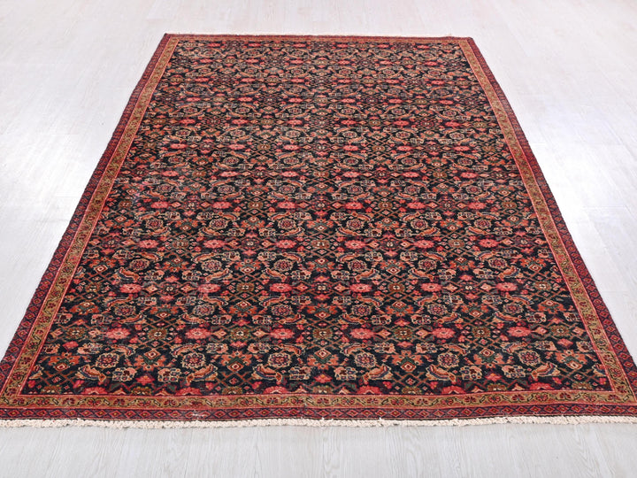 a black and red rug on a wooden floor