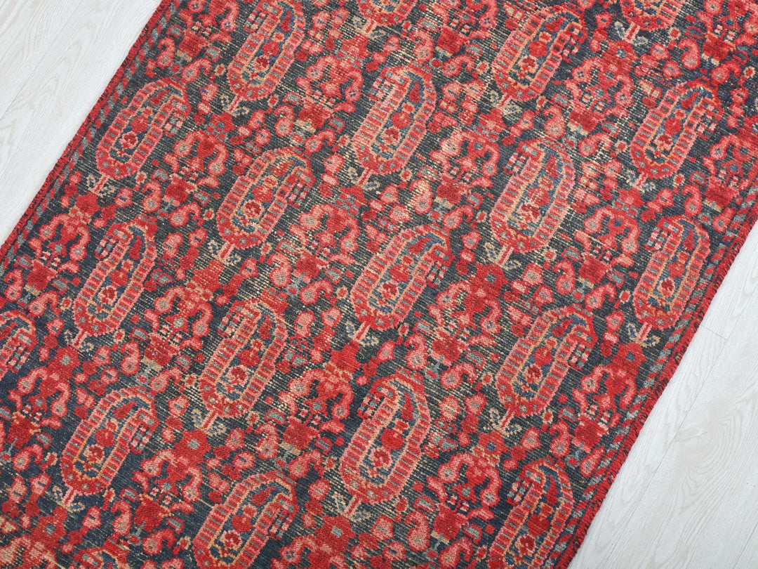 a red and black rug on a white floor