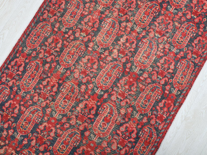 a red and black rug on a white floor