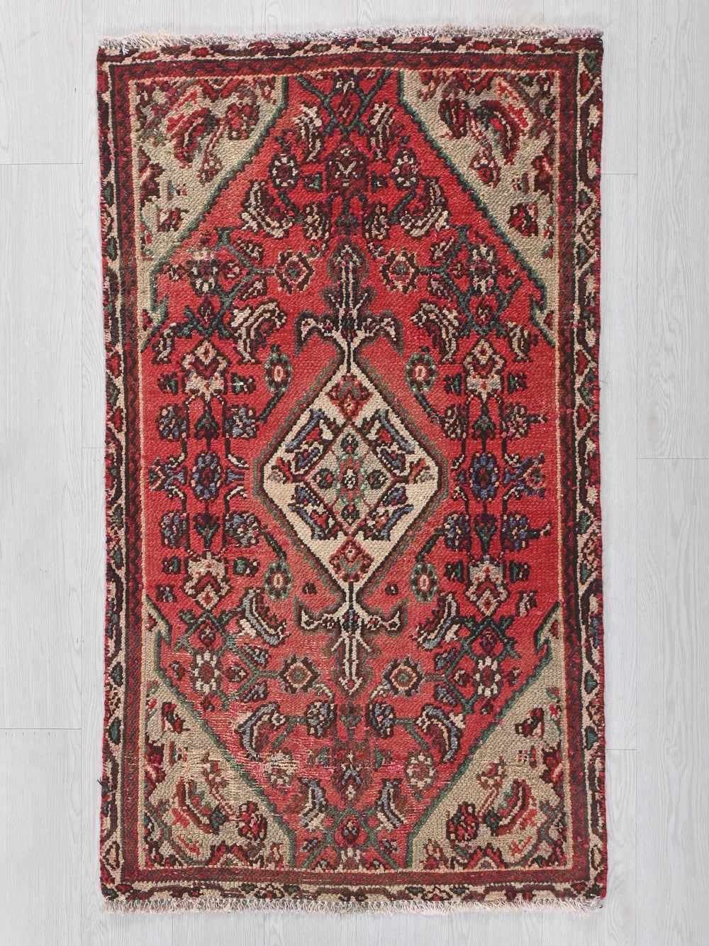 a red rug with a diamond shaped design