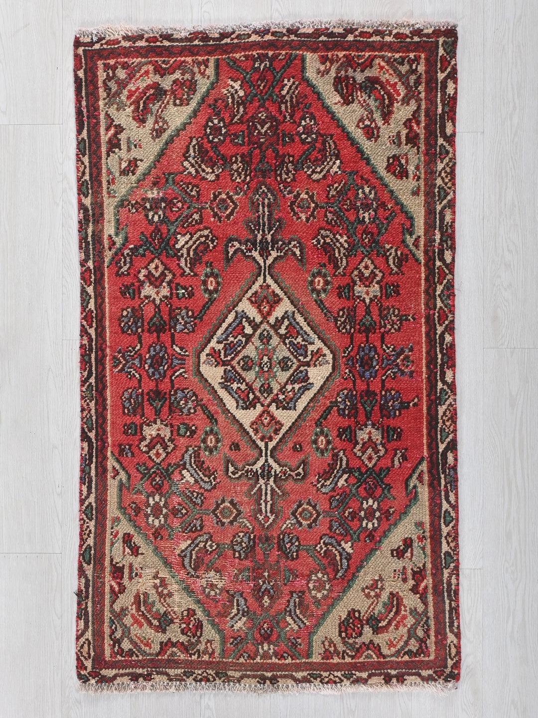a red rug with a diamond shaped design