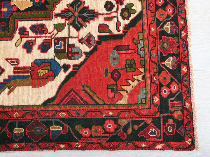 a red rug with a black border on a white surface